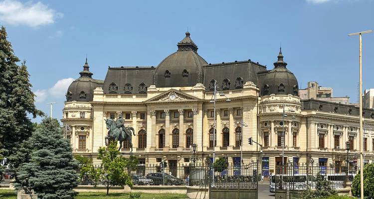 Grand neoclassical university library with equestrian statue in sunny square