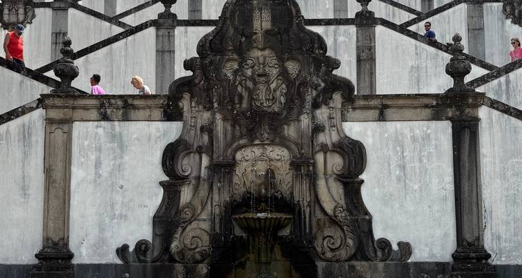 Fontaine et escalier de style baroque situés dans un sanctuaire monumental édifié sur une colline.