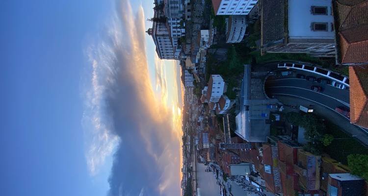 Vue panoramique des toits de Porto et du fleuve au coucher de soleil dramatique avec des nuages lumineux.