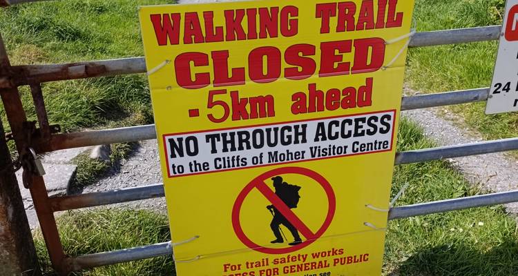 Gros plan d'une pancarte jaune vif annonçant la fermeture du sentier vers les Falaises de Moher.