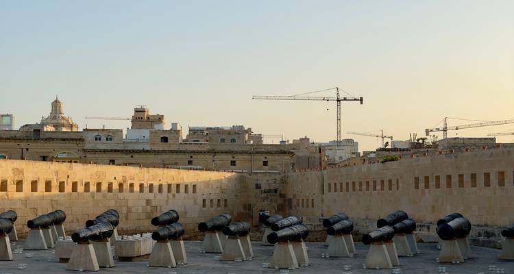 Row of historic black cannons on stone platforms at the Saluting Battery.