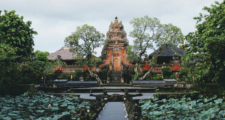 Temple balinais traditionnel entouré de bassins de lotus et de verdure luxuriante