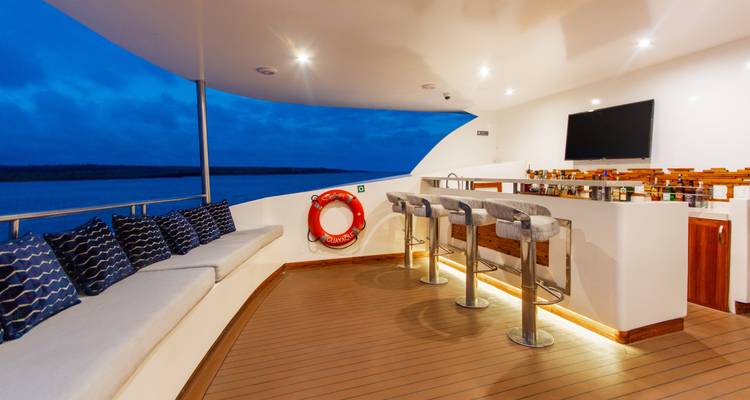 Evening bar deck on a yacht with stools, lifebuoy and ambient lighting over calm sea