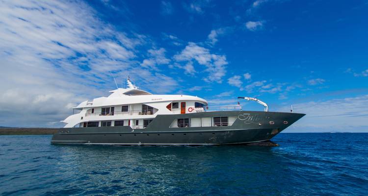 Side profile of luxury motor yacht Ilalo cruising on clear blue Pacific waters