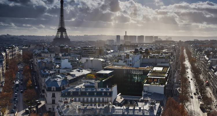 Panoramablick auf die Pariser Skyline mit dem Eiffelturm unter dramatischen Sonnenstrahlen