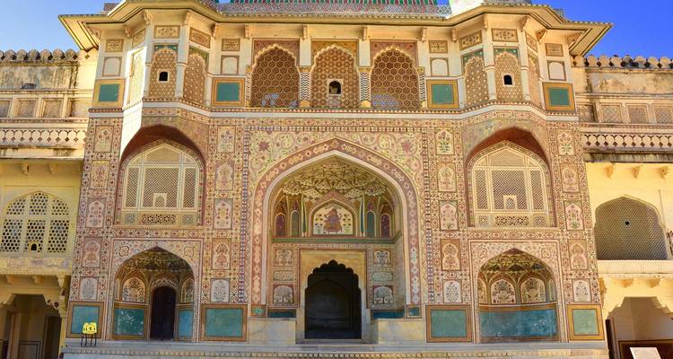 gedetailleerde geschilderde gevel en gewelfde poorten van Amber Fort in fel zonlicht