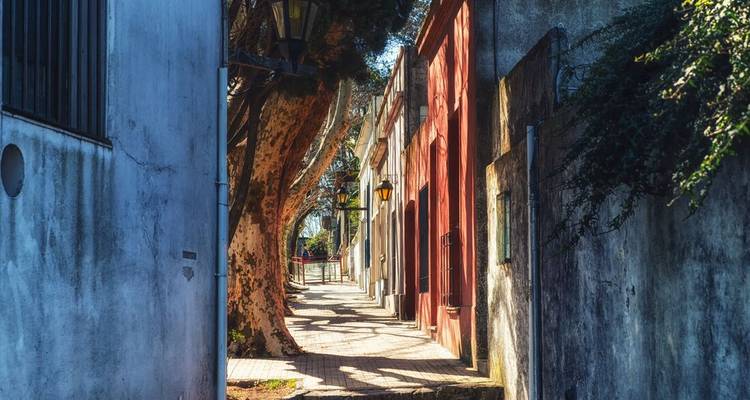 Ruelle tranquille et étroite aux murs coloniaux colorés et à la lumière du soleil tachetée dans la ville historique en bord de rivière