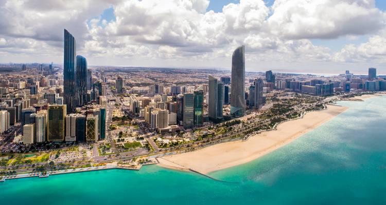 Luftaufnahme einer Golfmetropole mit türkisfarbenem Meer und Strandpromenade-Skyline