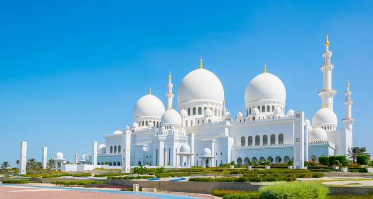 Glänzende weiße Kuppeln einer großartigen Moschee strahlen gegen den klaren Wüstenhimmel