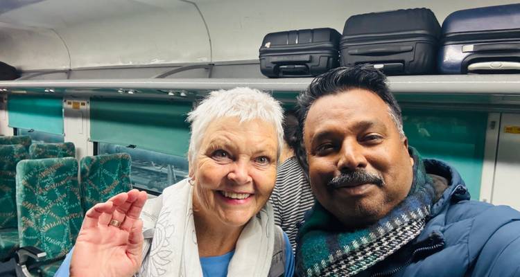 Traveller and tour guide take a cheerful selfie inside a modern train carriage