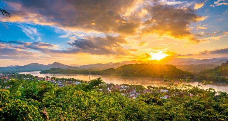 Vue du coucher de soleil sur Luang Prabang avec le Mékong sinuant entre les collines boisées