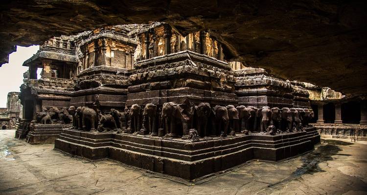 Stenen olifanten en gedetailleerde beeldhouwwerken omringen de basis van de Kailasa-tempel in Ellora