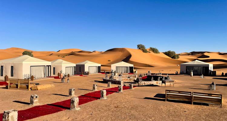 Luxury tent camp set amid rolling golden sand dunes of the Sahara
