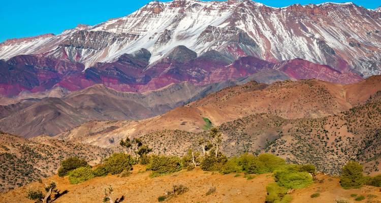 Colorful layered peaks of the Atlas Mountains capped with snow