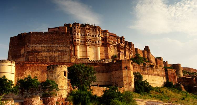 Imposante Sandsteinmauern der Mehrangarh-Festung, die sich unter sanftem Nachmittagslicht über einen felsigen Hang erheben