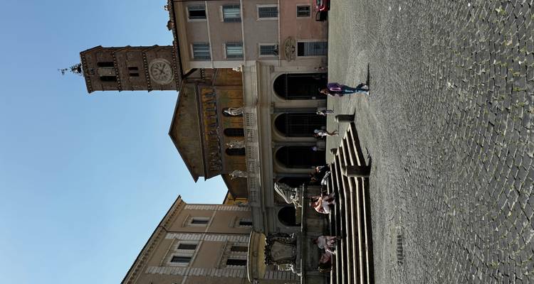 Zonnig plein met fontein en de middeleeuwse Basilica di Santa Maria in Trastevere.