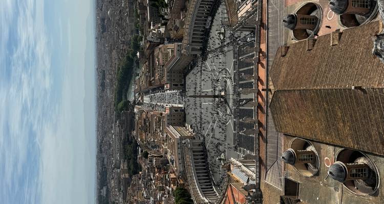 Panoramisch luchtfoto van Sint-Pietersplein, de Vaticaanse zuilengalerijen en Rome dat zich uitstrekt tot in de verre bergen.