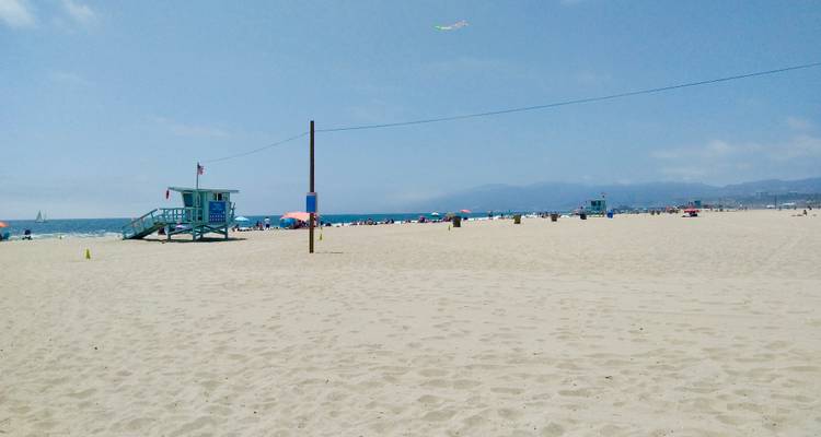 Plage de sable vaste avec des tours de surveillance et des parasols éloignés