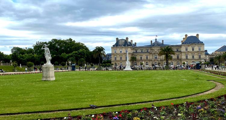 Les pelouses impeccablement entretenues et les statues des Jardins du Luxembourg s'étendent devant le grand Palais du Luxembourg.