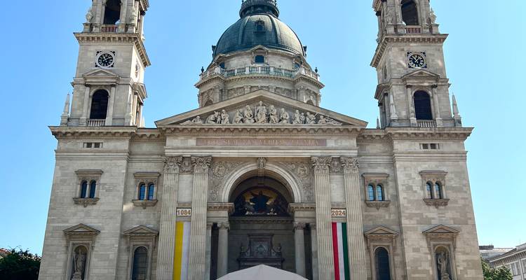 Frontansicht der Stephansbasilika mit zwei Glockentürmen und prächtige Kuppel bei hellem Tageslicht.