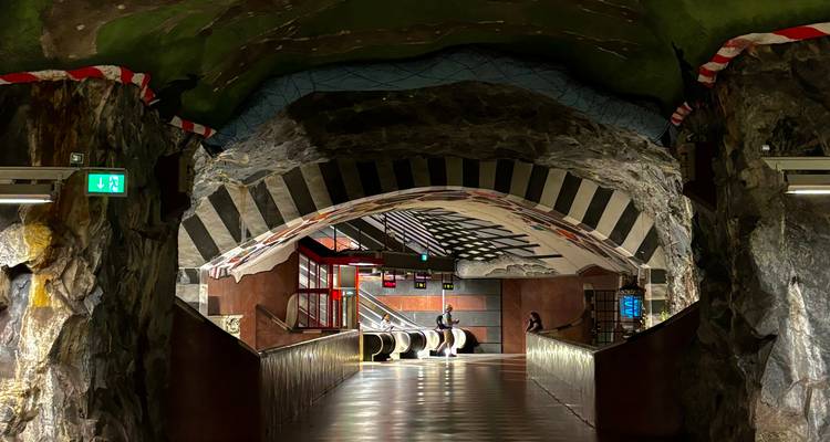 Tunnel rocheux aux rayures dramatiques d'une station de métro de Stockholm avec un seul passager.