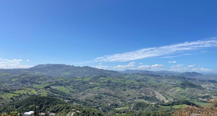 vue panoramique large de collines et de vallées verdoyantes ondulantes sous un ciel bleu éclatant