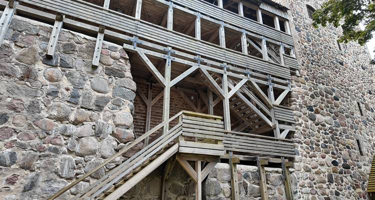 Close-up of wooden galleries and stone walls of a medieval castle.