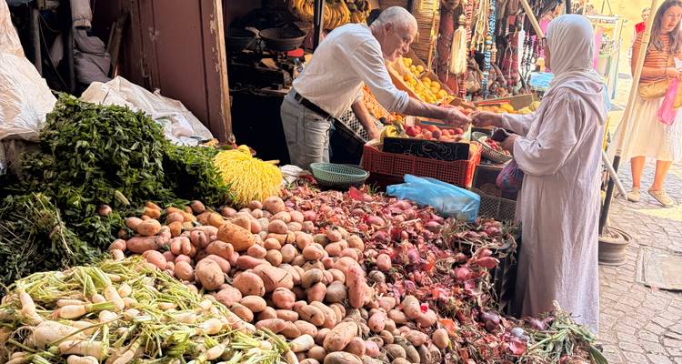 Vendedor pesando productos para una clienta con velo en un puesto de verduras vibrante en el zoco