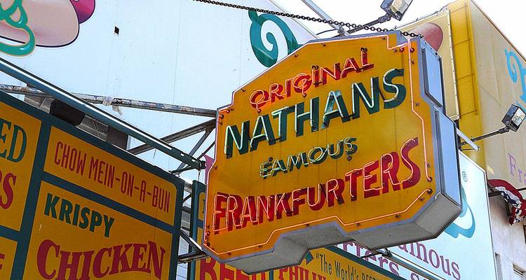 Colorful vintage sign for Nathan’s Famous Frankfurters against a backdrop of playful graphics
