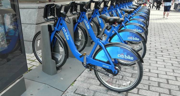 Row of blue Citi Bikes docked on a cobblestone station in New York