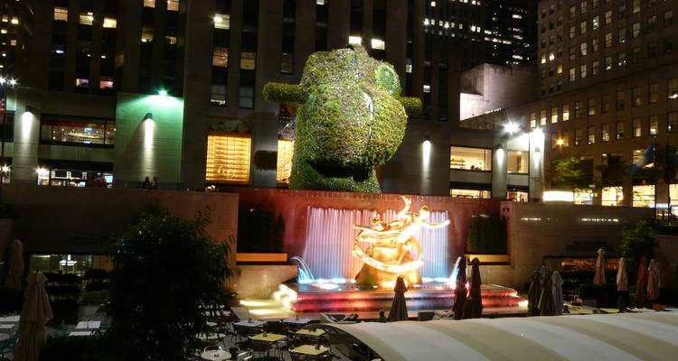 Night shot of Rockefeller Center’s Prometheus fountain illuminated by colorful lights