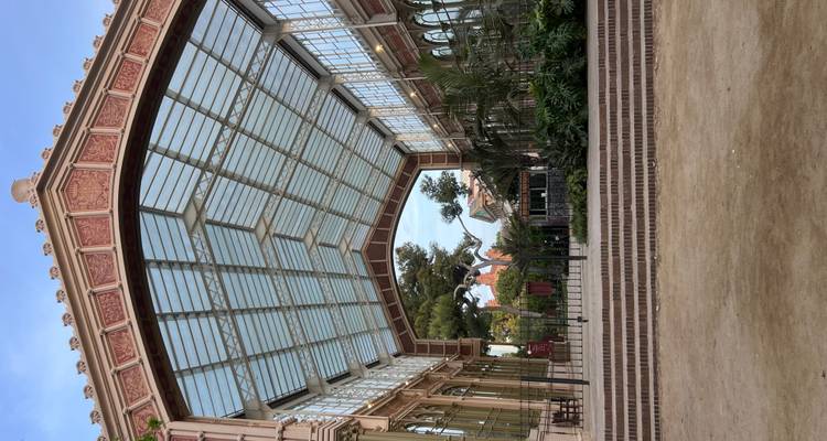 Structure de serre en fer avec toit de verre contenant des plantes alignées à l'intérieur du Parc de la Ciutadella