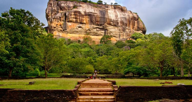Stenen trappenroute die leidt naar de massieve rotsfortuin van Sigiriya die uittorent boven het groene oerwoud.
