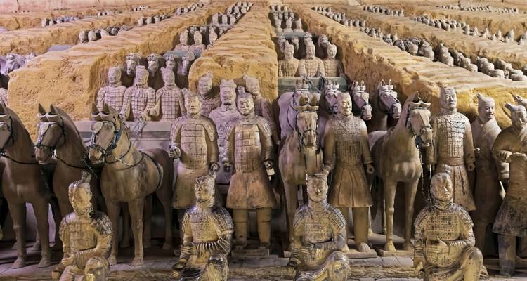 Filas de Guerreros de Terracota de tamaño natural y caballos se encuentran en formación ordenada dentro de la fosa excavada del antiguo mausoleo.