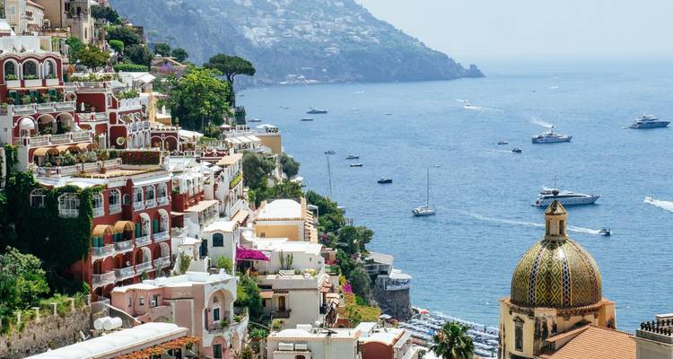 Picturesque Positano cascading down Amalfi Coast cliffs with boats in azure sea.