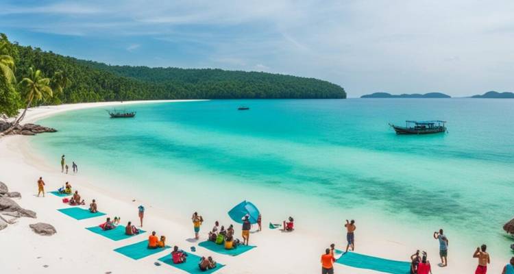 Tropical Cambodian island beach with turquoise water where tourists practice yoga on mats.