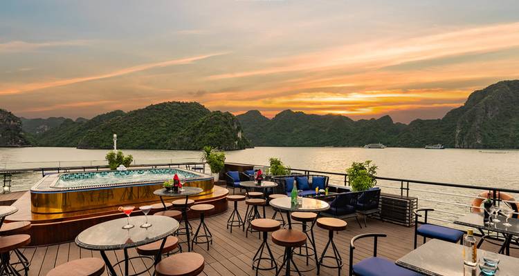 Bar en plein air avec bain à remous dominant la baie d'Halong au coucher du soleil