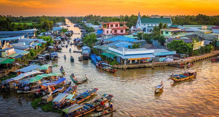 Lebendige Luftaufnahme eines geschäftigen Mekong-Schwimmmarkts bei Sonnenuntergang.