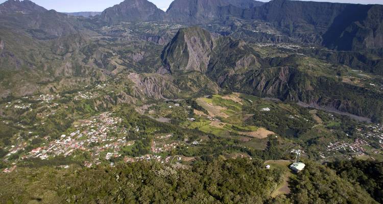 Wide aerial panorama of rugged mountain cirques and scattered settlements.