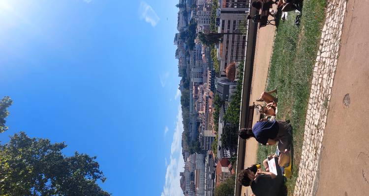 Jonge mensen die ontspannen op een grasparkje op een heuvel met een panoramisch uitzicht over de terracotta daken van Lissabon