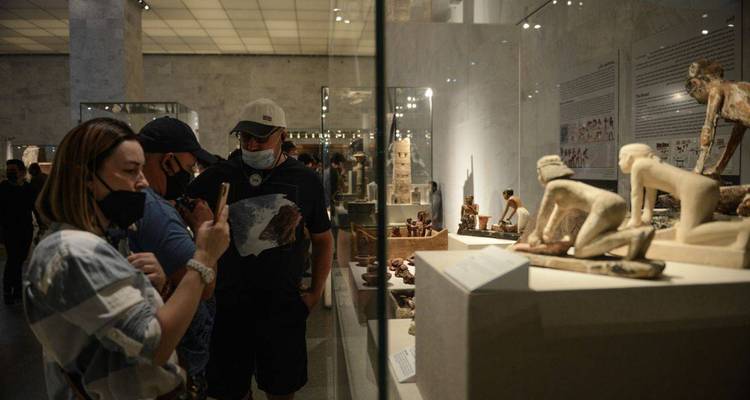 Visitantes observando artefactos antiguos dentro de una vitrina de museo