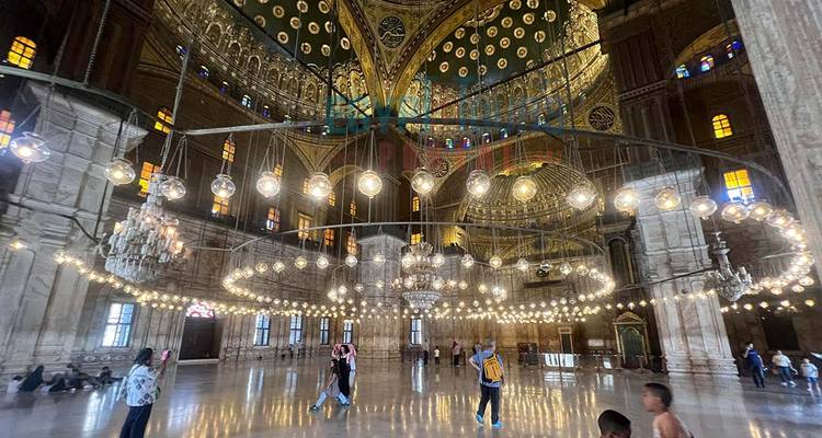 Interior de mezquita decorado lujosamente con lámparas de vidrio colgantes y arañas de luces circulares