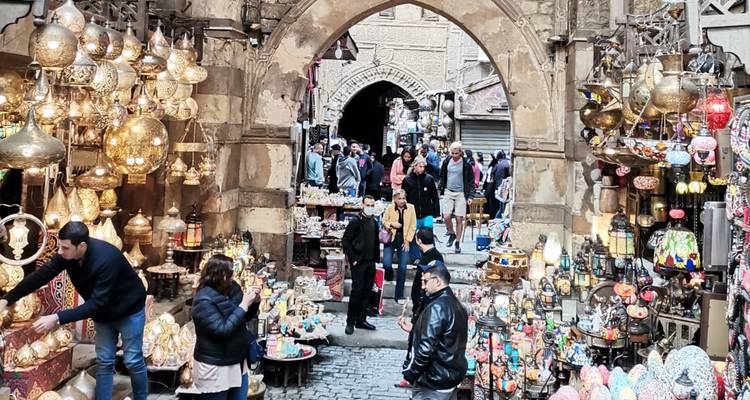 Callejón de mercado tradicional repleto de gente, decorado con faroles coloridos y souvenirs