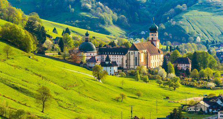 Abbaye et village baignés de soleil nichés dans les collines verdoyantes de la Forêt-Noire.