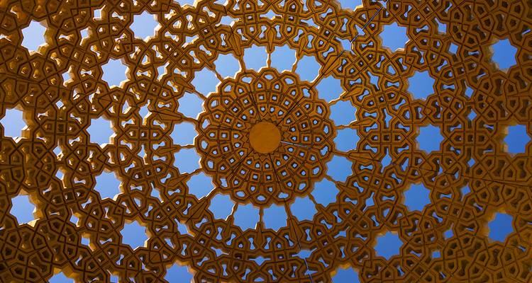 Komplexes goldenes islamisches geometrisches Deckenmuster, von direkt unten betrachtet.