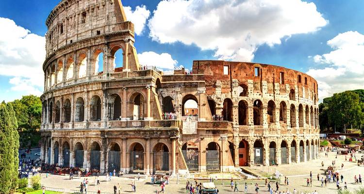 Iconic Colosseum bathed in daylight with crowds exploring the ancient Roman amphitheatre.