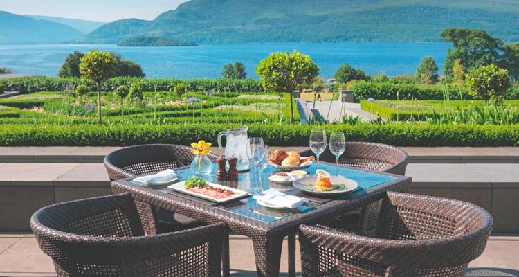 Outdoor-Hotelterrassen-Speisegarnitur mit Speisen mit Blick auf den Lough Leane und die Berge.