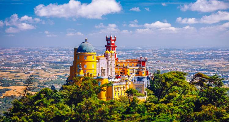 Vibrant Palais de Pena perché au sommet de collines boisées surplombant la campagne portugaise.