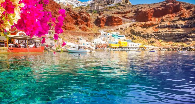 Klares Wasser in Aquamarin und farbenfrohe Klippen rahmen die Ammoudi Bucht unterhalb von Oia auf Santorini ein.