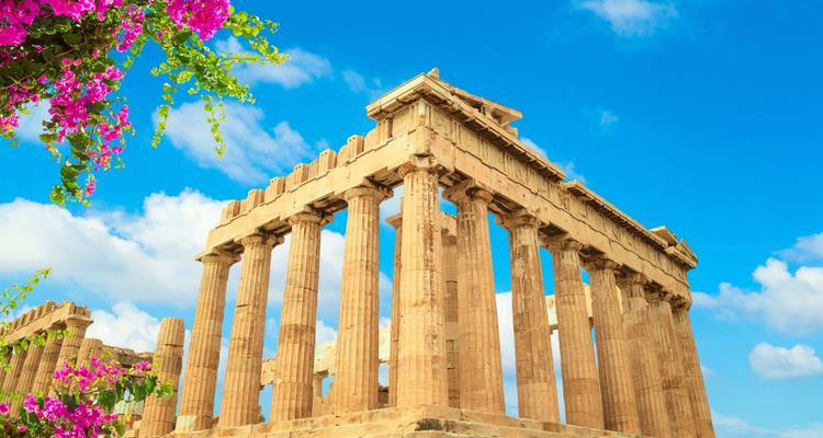 De Parthenon tempel staat onder een levendige blauwe lucht omrand door bloeiende bougainville.